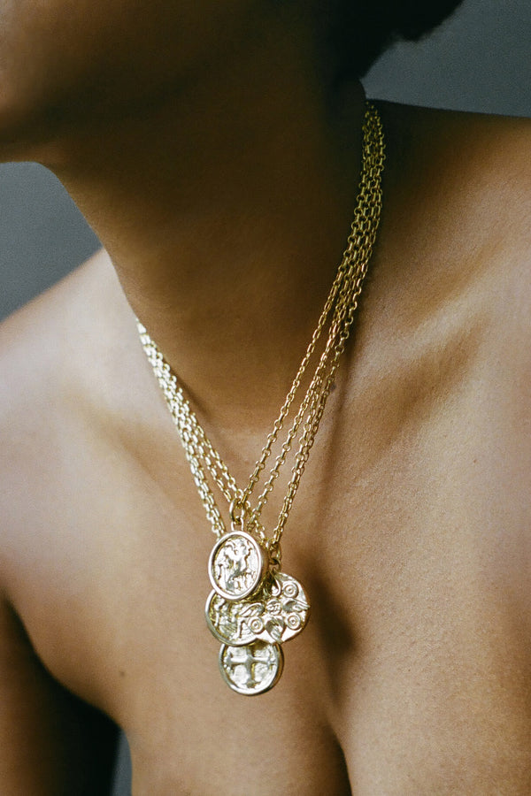 Model wearing AMS x LL gold Saint Basil Pendant