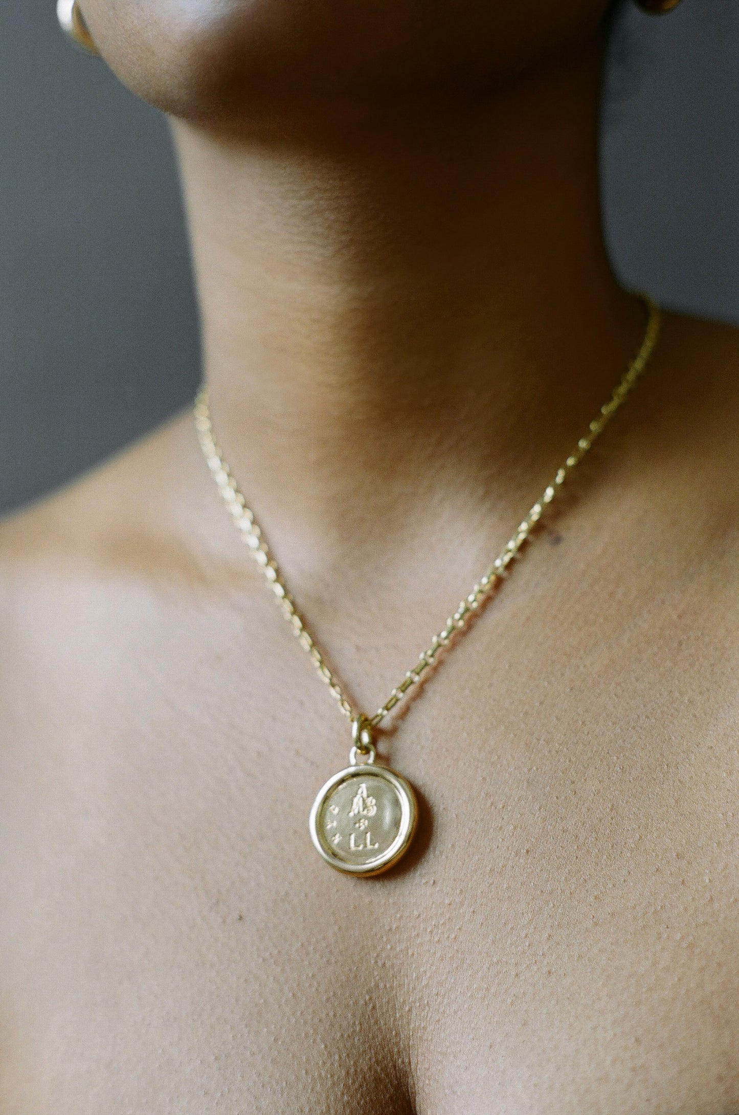 Model wearing AMS x LL gold Saint Basil Pendant