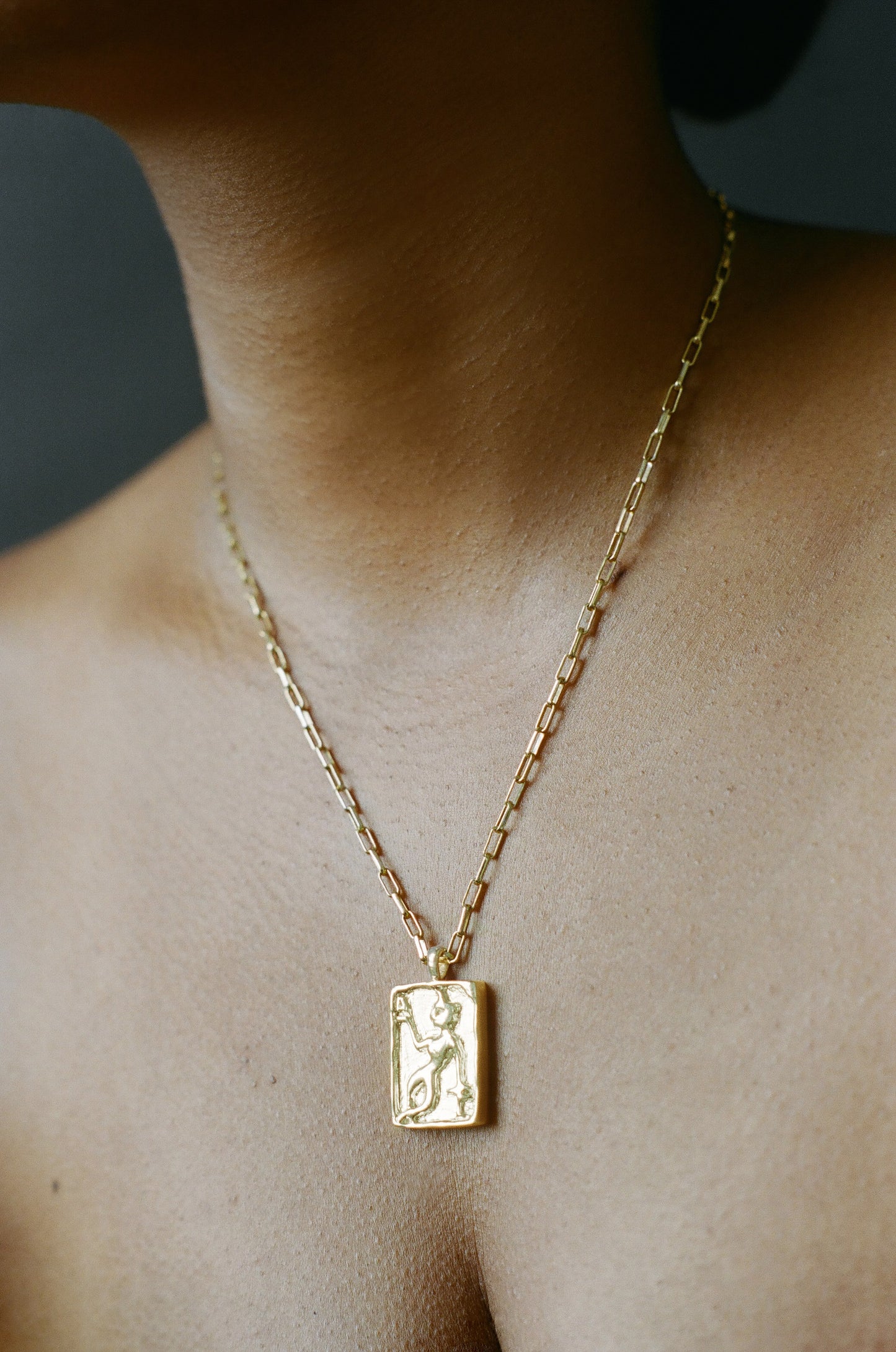 Model wearing AMS x LL gold Dancer Pendant