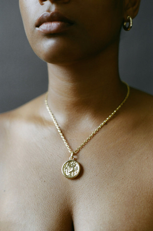 Model wearing AMS x LL gold Guide Pendant