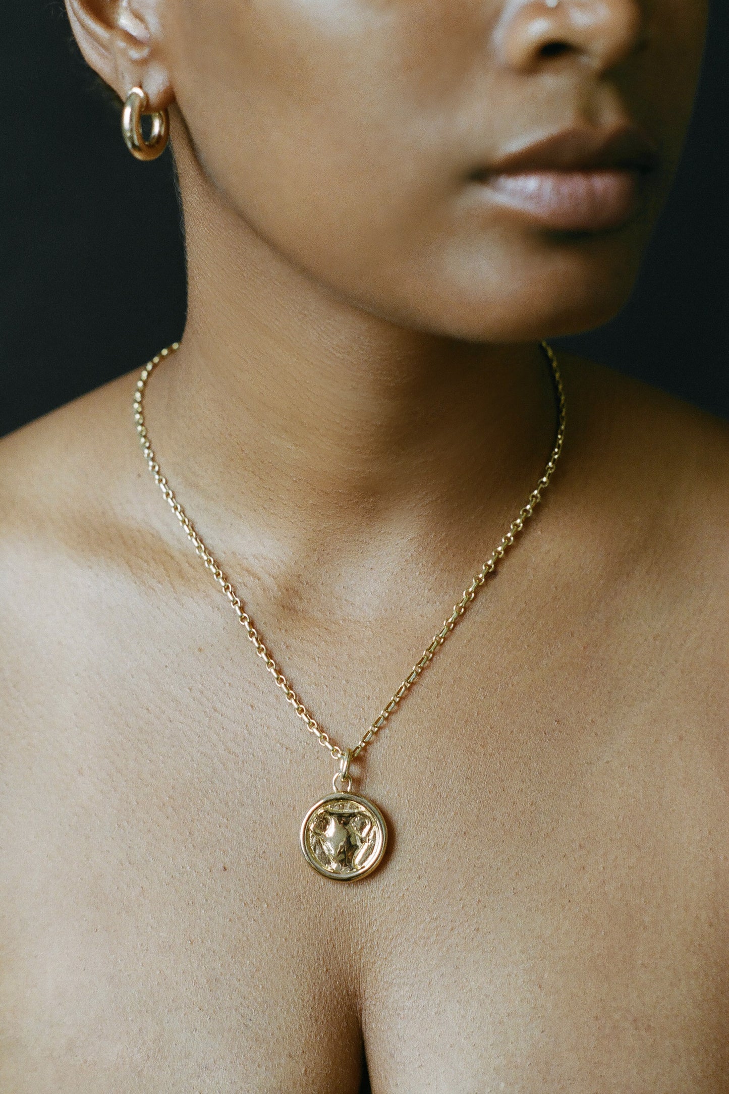 Model wearing gold AMS x LL Heaven Sip Pendant