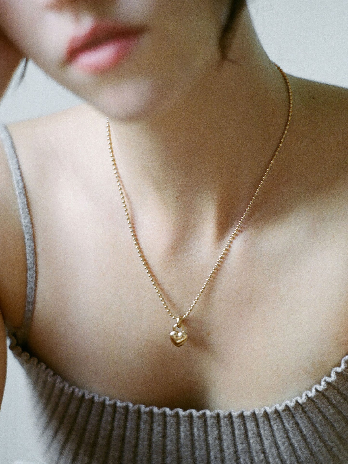 Model wearing Laura Lombardi gold Mini Amorina Pendant