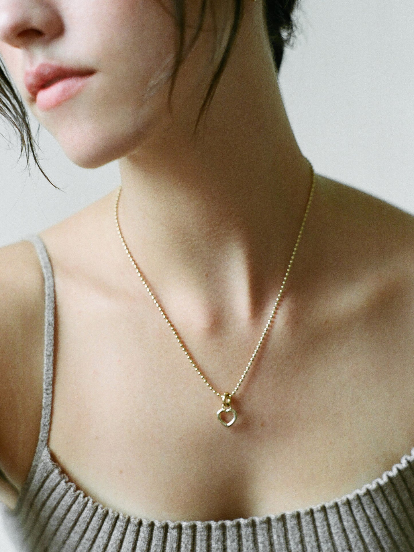 Model wearing Laura Lombardi gold Mini Teresa Pendant