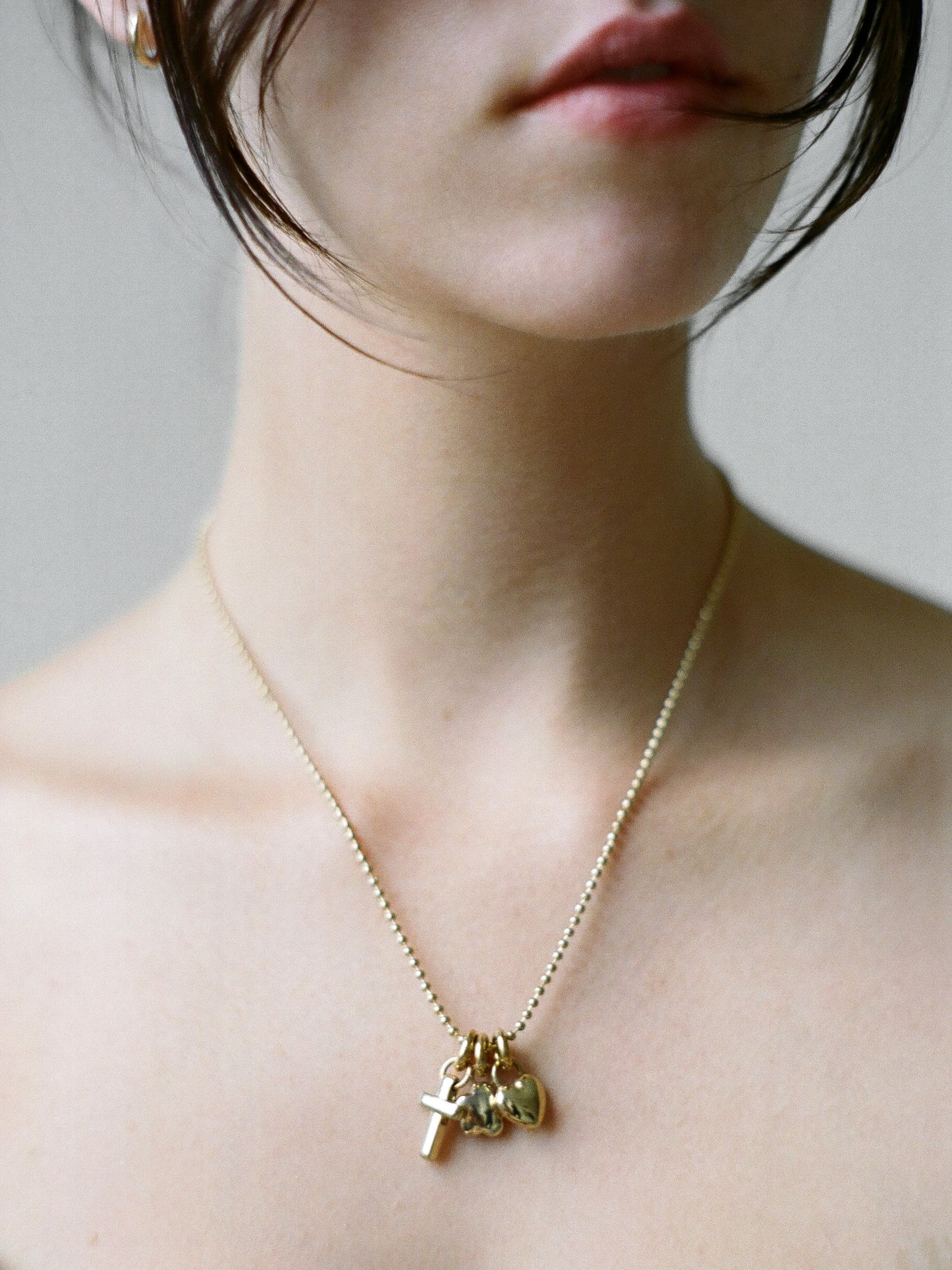 Model wearing Laura Lombardi gold Multi Charm Pendant