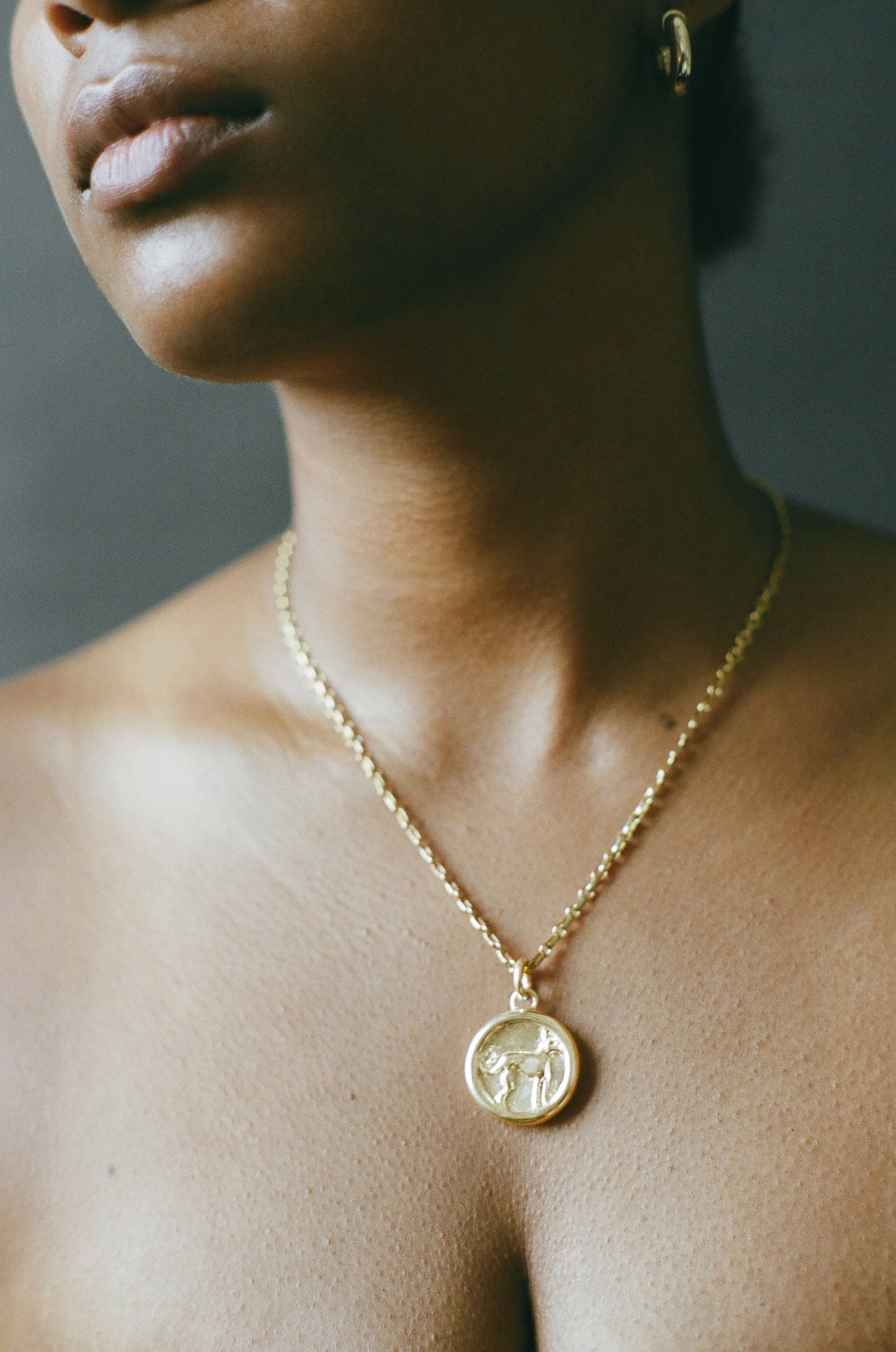 Model wearing AMS x LL gold Protection Pendant