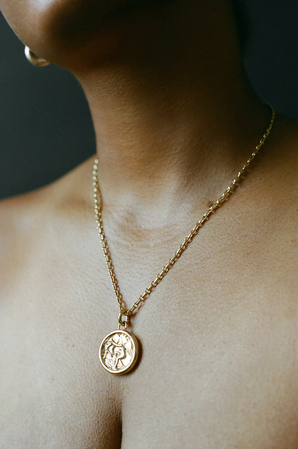 Model wearing gold AMS x LL Seduced By An Angel Pendant