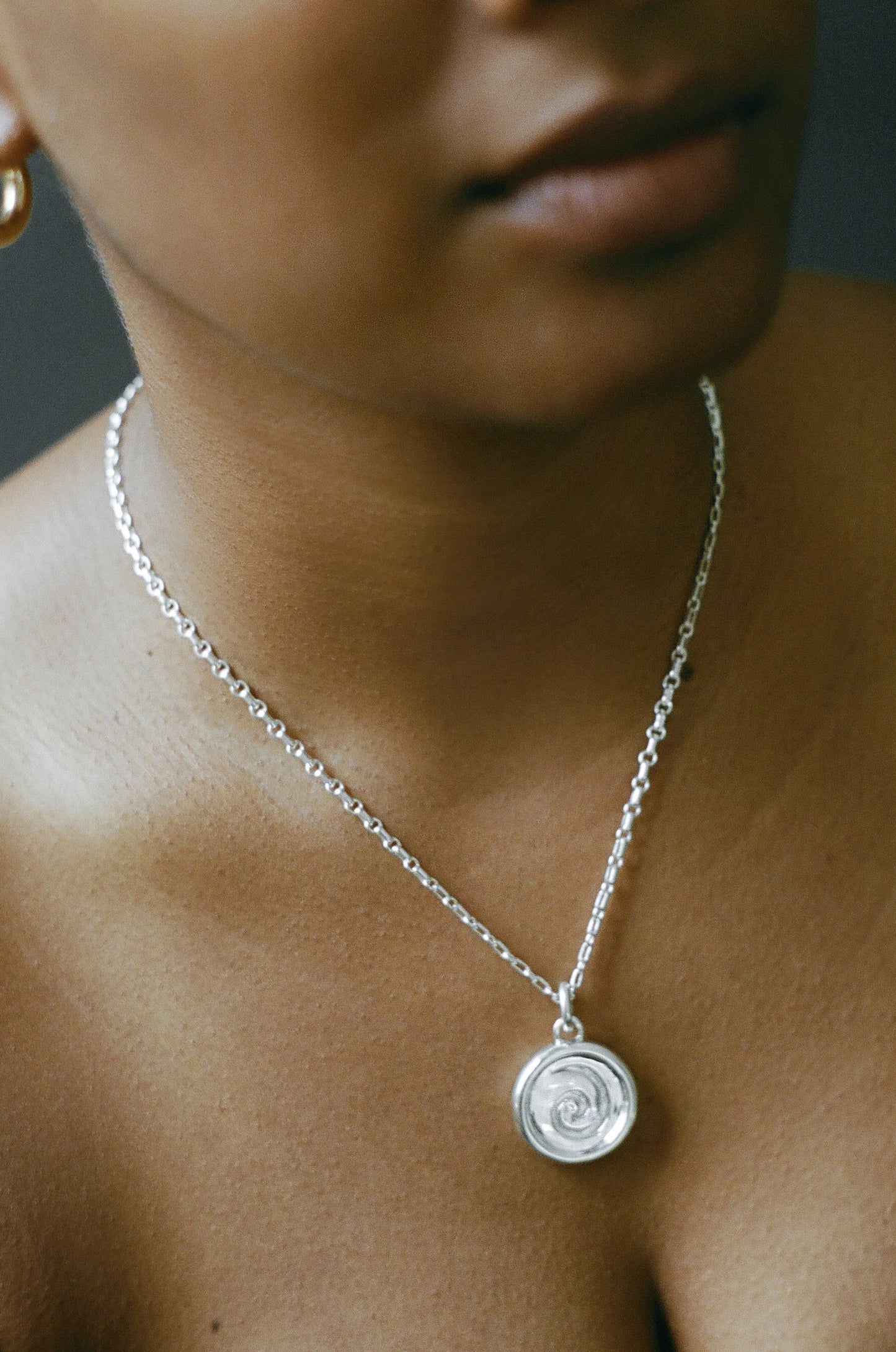 Model wearing AMS x LL Silver Spiral Pendant