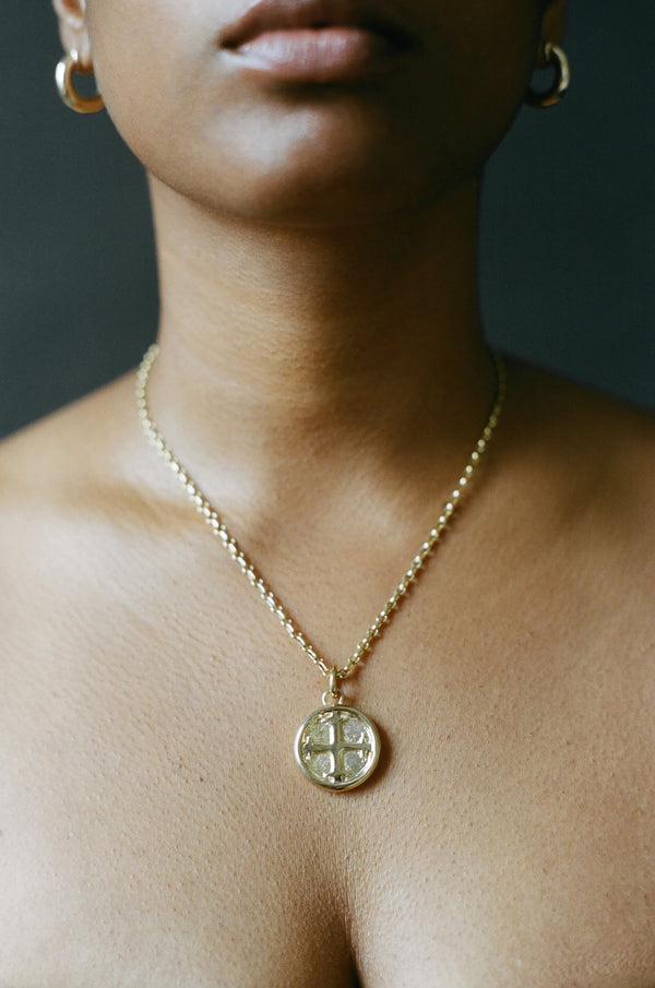 Model wearing AMS x LL gold Saint Basil Pendant