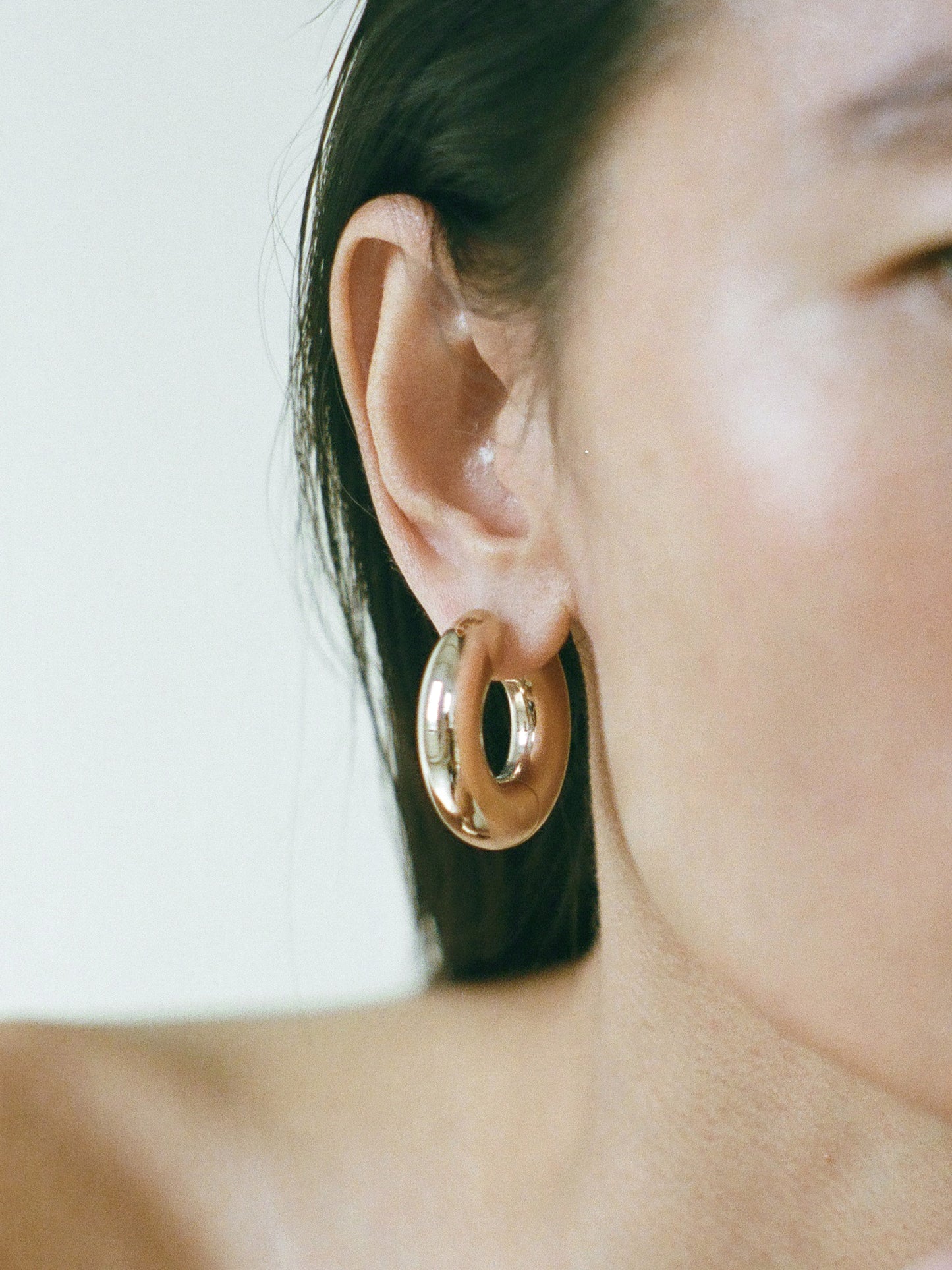 Model wearing Laura Lombardi gold Large Terra Hoops