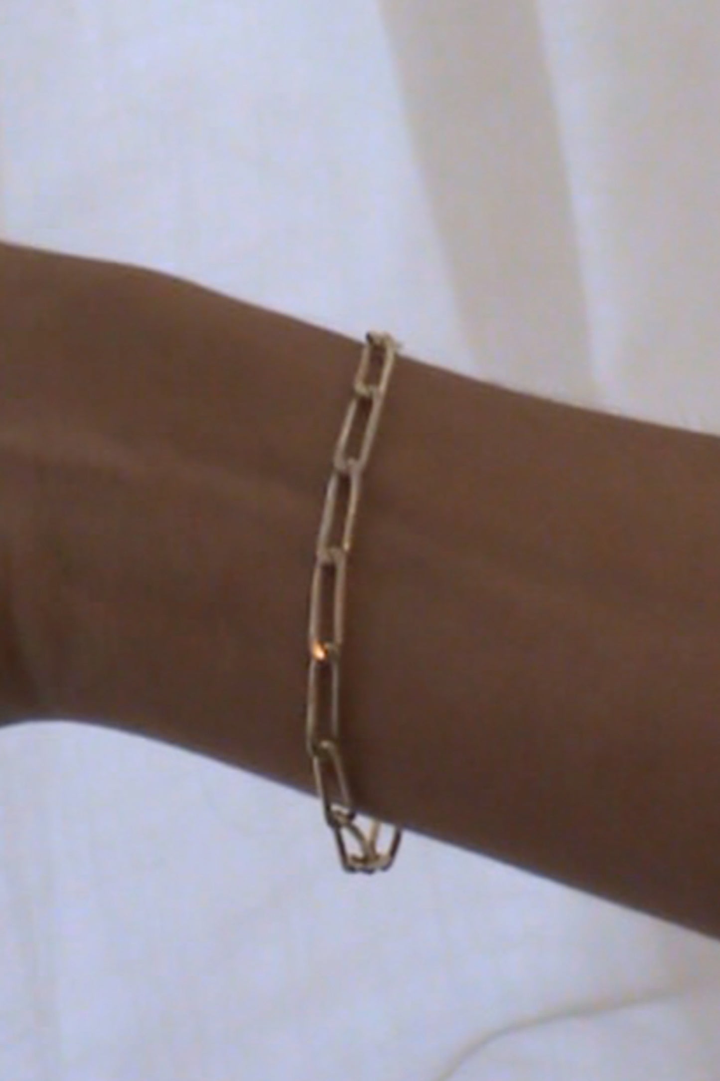 Model wearing Laura Lombardi gold figaro-inspired Adriana chain bracelet.