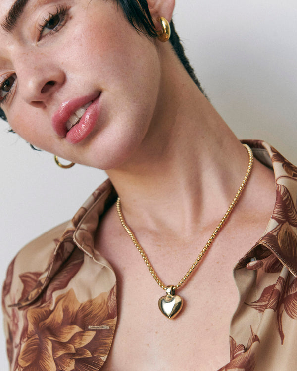 Model wearing Laura Lombardi gold Chiara heart pendant necklace.