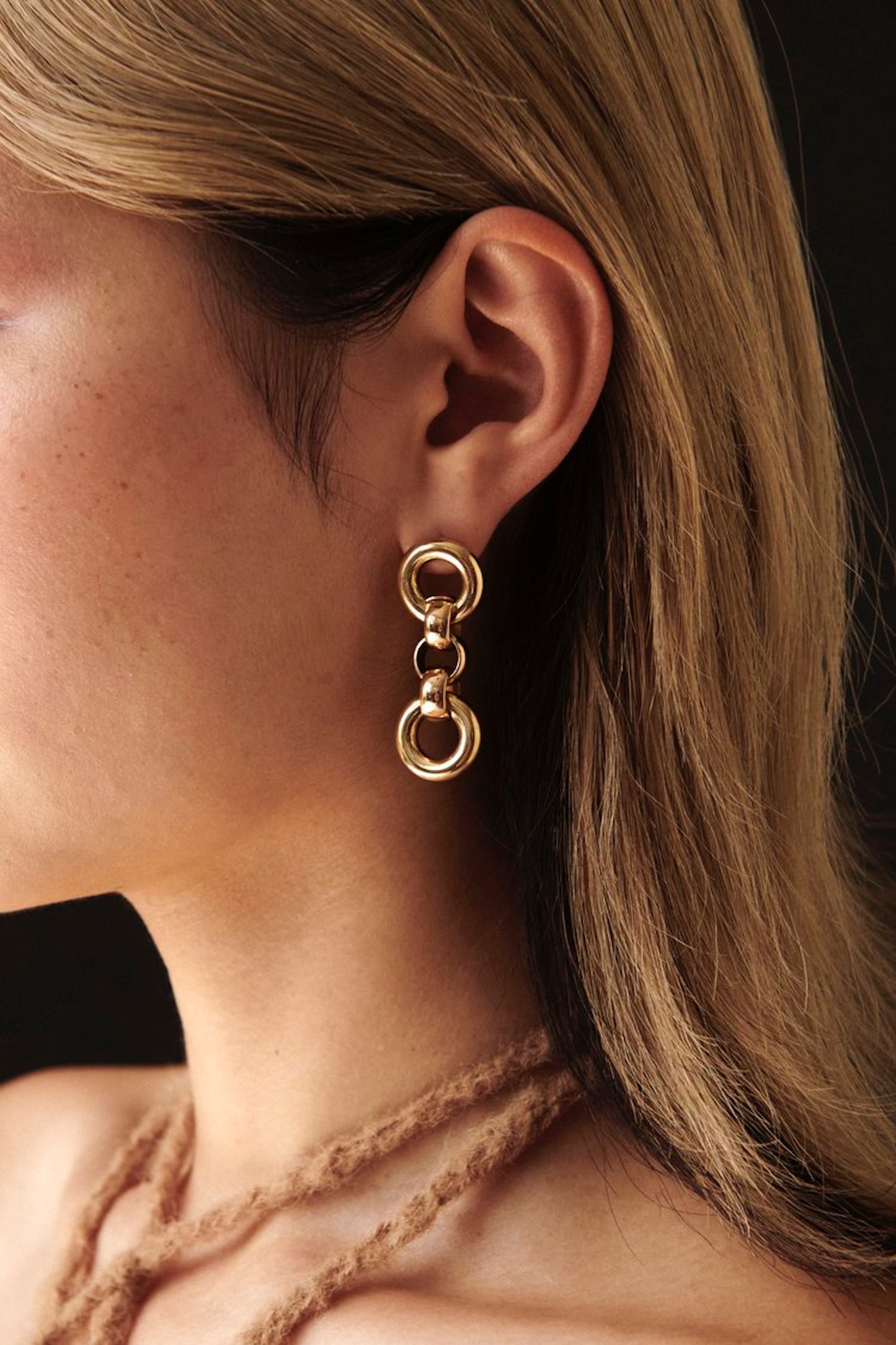 Side profile of model wearing Laura Lombardi gold Cinzia drop earrings.