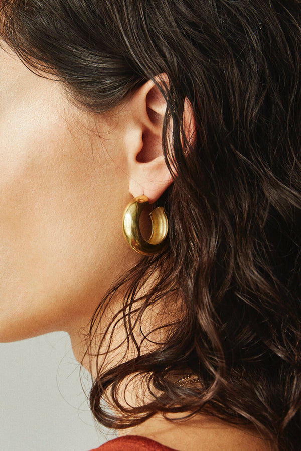 Side profile of model wearing Laura Lombardi gold Cusp Hoops.