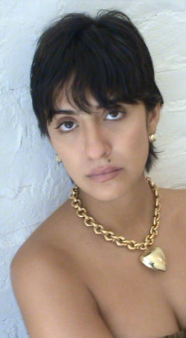 Model wearing Laura Lombardi gold Giulietta Necklace with oversized heart pendant.