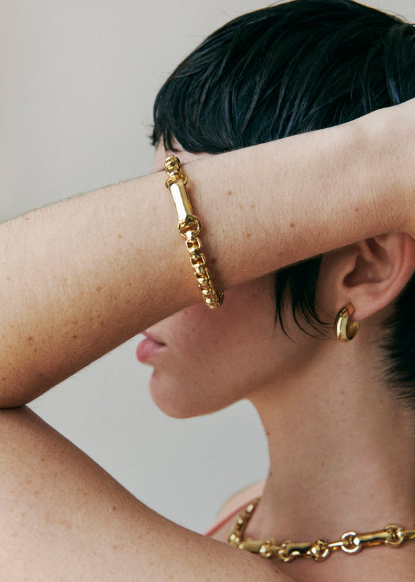 Model wearing Laura Lombardi gold Lella Bracelet with Mini Cusp Hoops and Sienna Necklace.