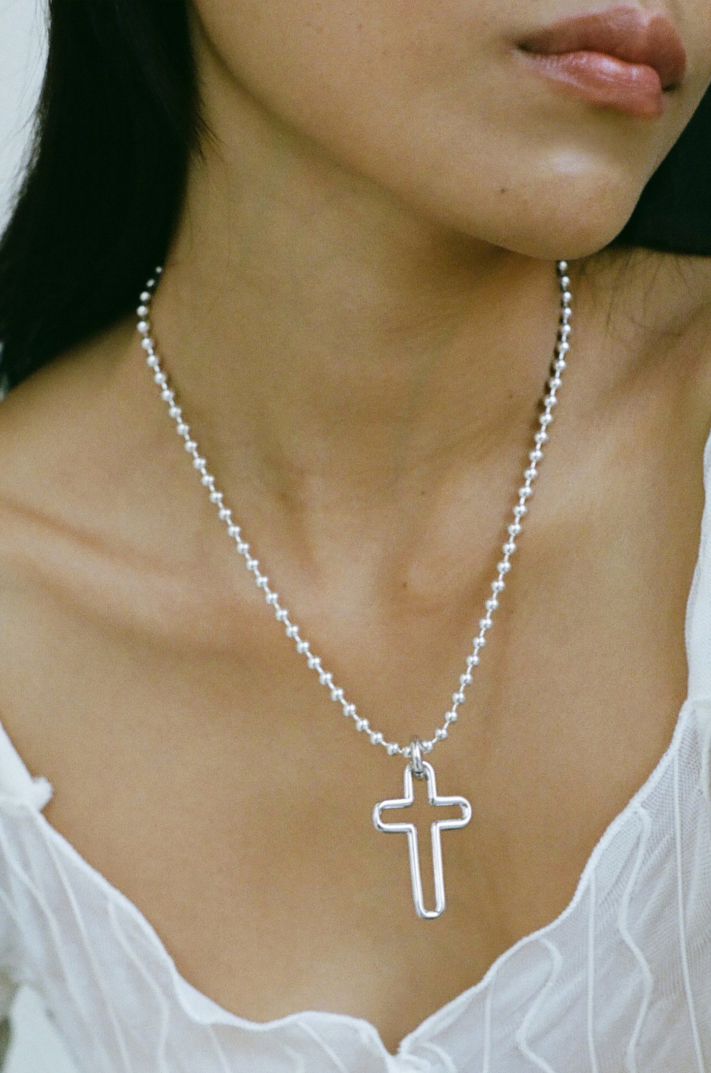 Model wearing Laura Lombardi Silver Madda cross pendant.