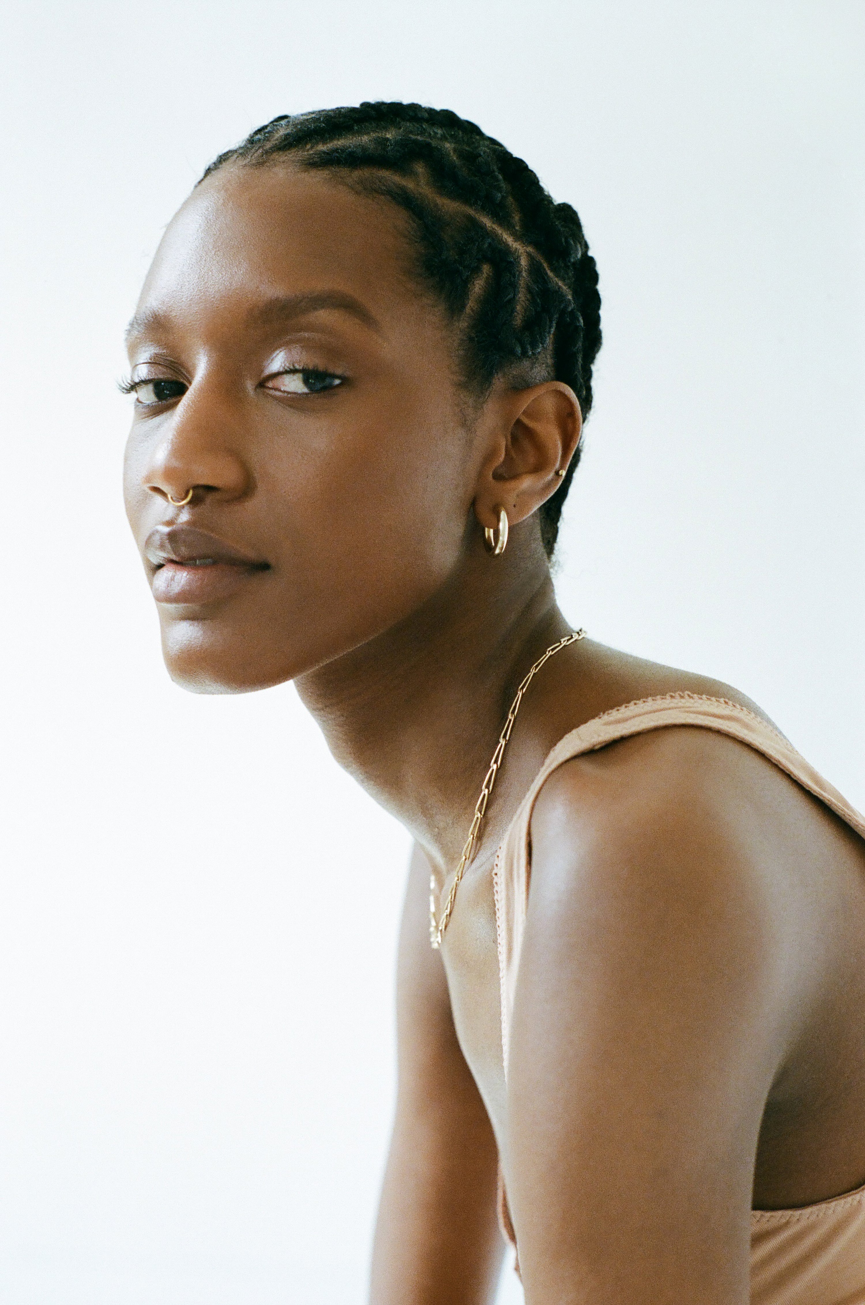 Model wearing Laura Lombardi gold medium hollow tube hoop earrings.