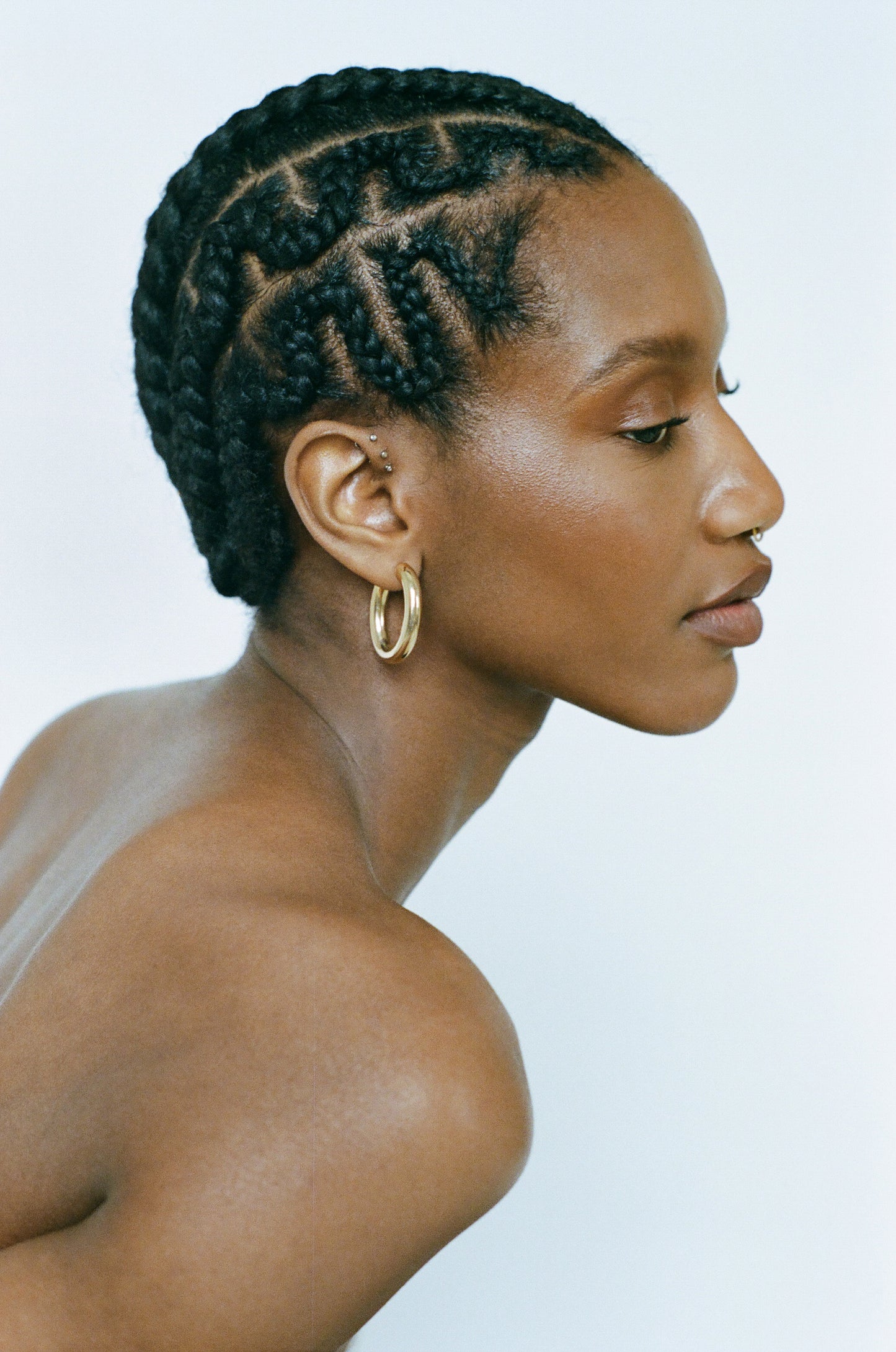 Side profile of model wearing Laura Lombardi gold Mini Curve Earrings.