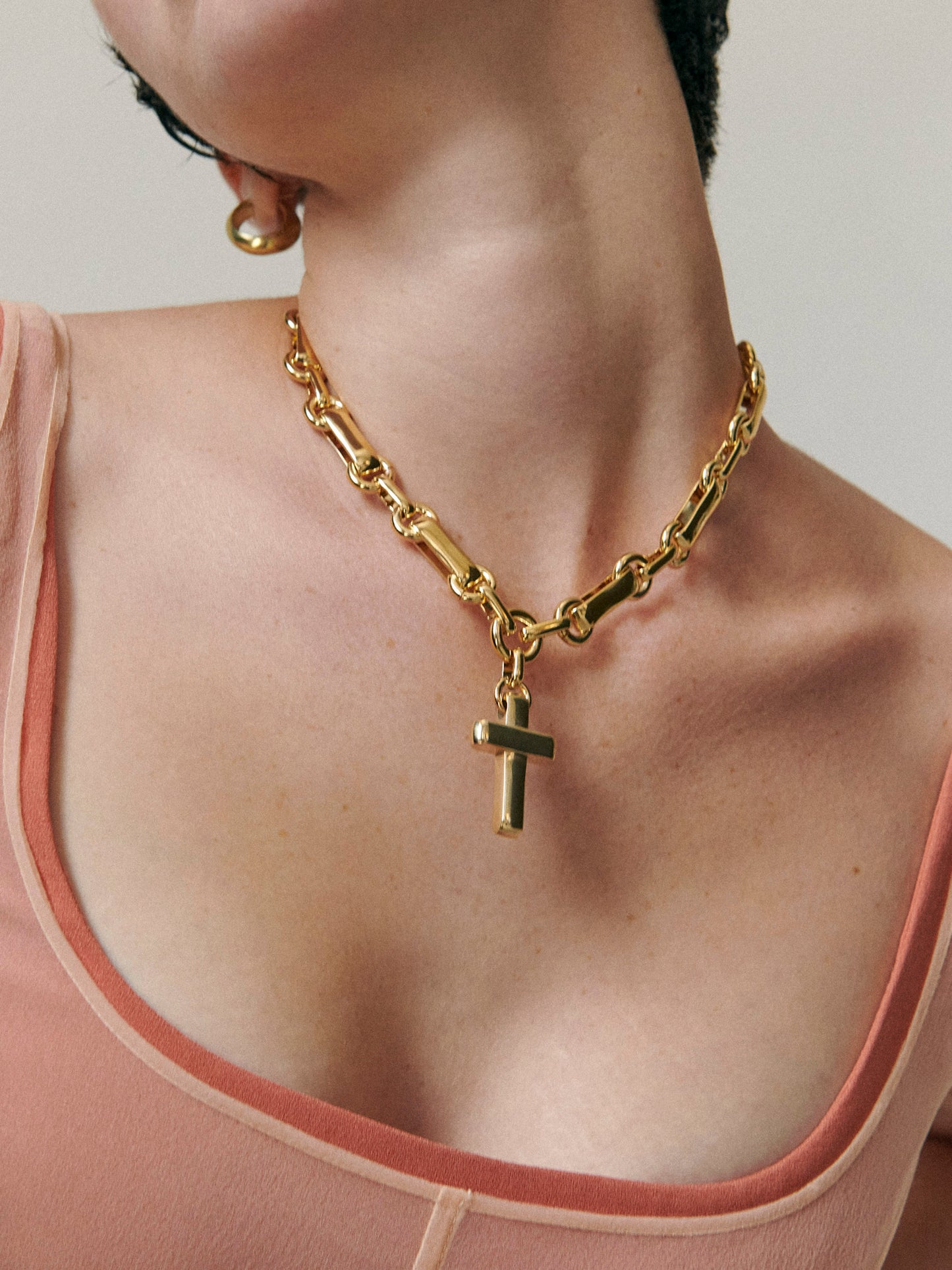 Model wearing Laura Lombardi gold Sestina cross necklace.