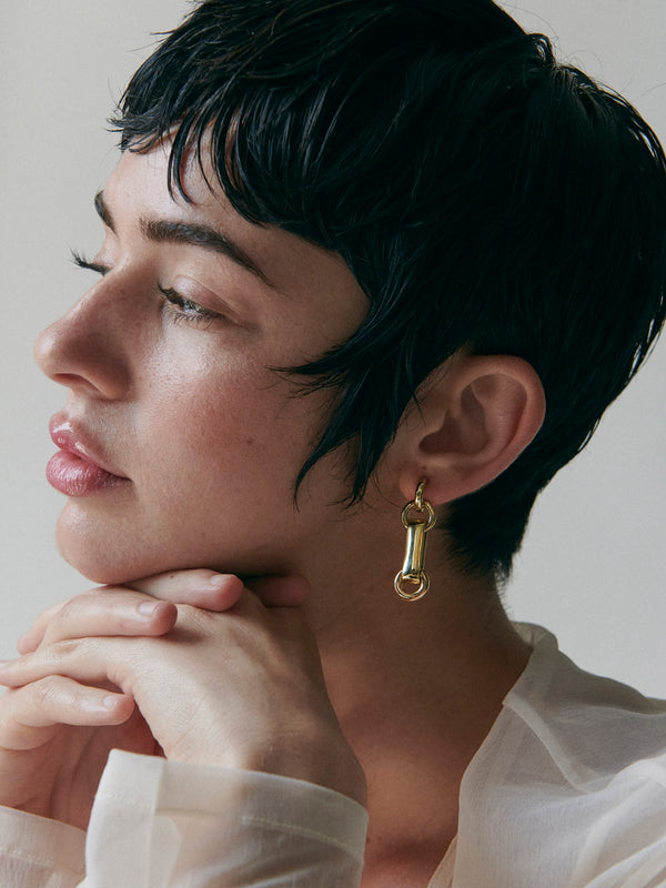 Side profile of model wearing Laura Lombardi gold Sienna Earrings.