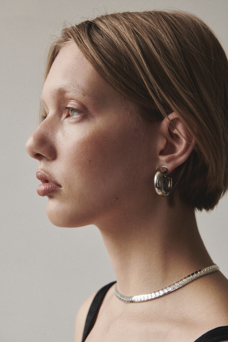 Side profile of model wearing Laura Lombardi Silver Cusp Hoops with Silver Piatta Necklace.