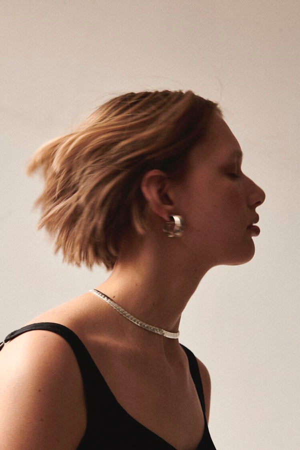 Side profile of model wearing Laura Lombardi Silver Cusp Hoops with Silver Piatta Necklace.