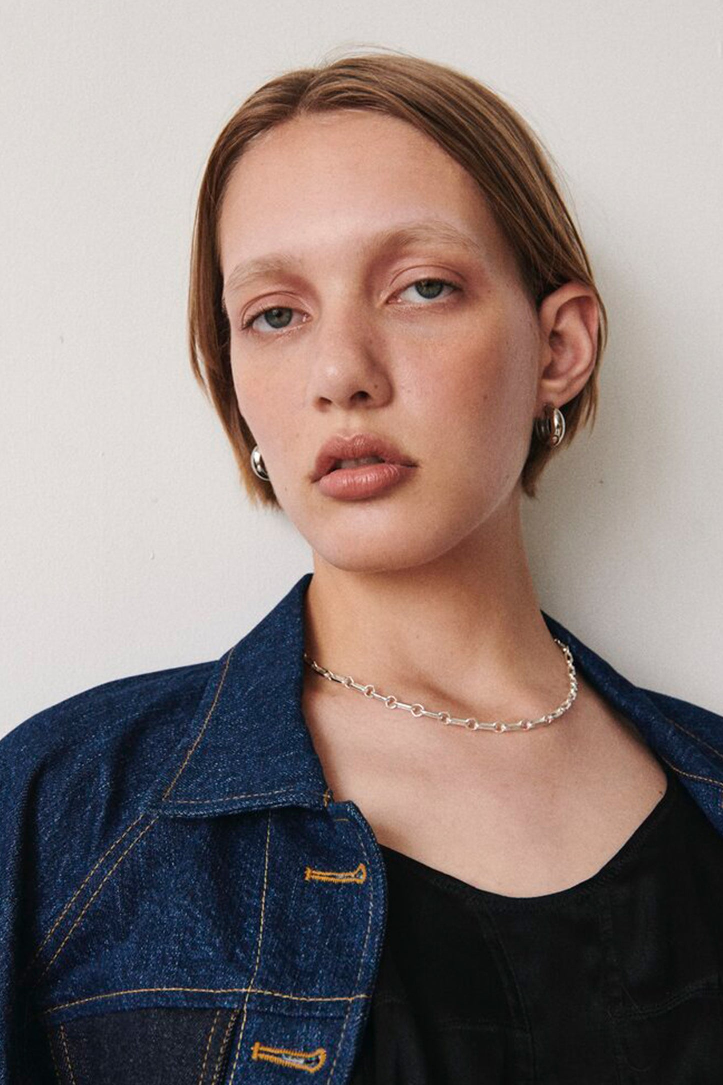 Model wearing Laura Lombardi Silver Mini Cusp Hoops and Silver Bar Chain.