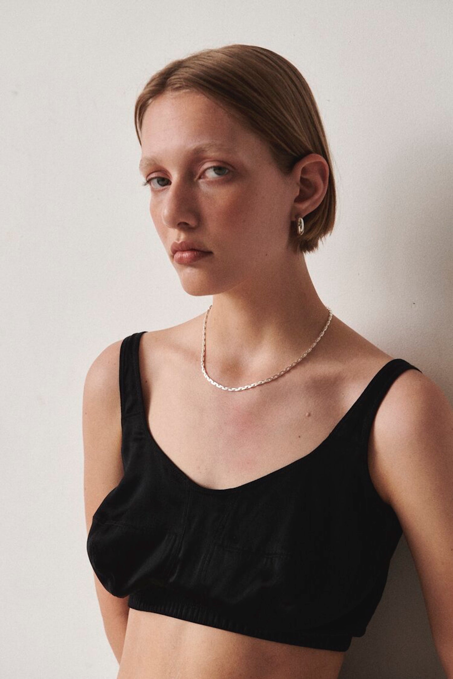 Model wearing Laura Lombardi Silver Mini Cusp Hoops and SIlver Strada Chain.