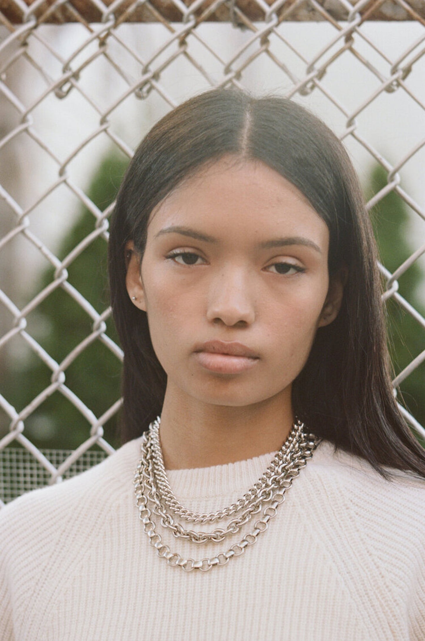 Model wearing layered Laura Lombardi silver chains.