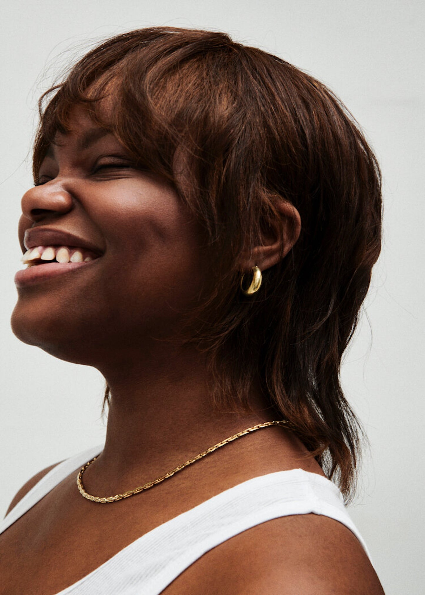 Model wearing Laura Lombardi gold Strada Necklace and Mini Cusp Hoops.